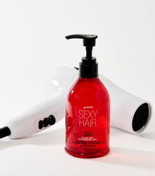 Big Blow Dry Volumizing Gel bottle with styling tools on white