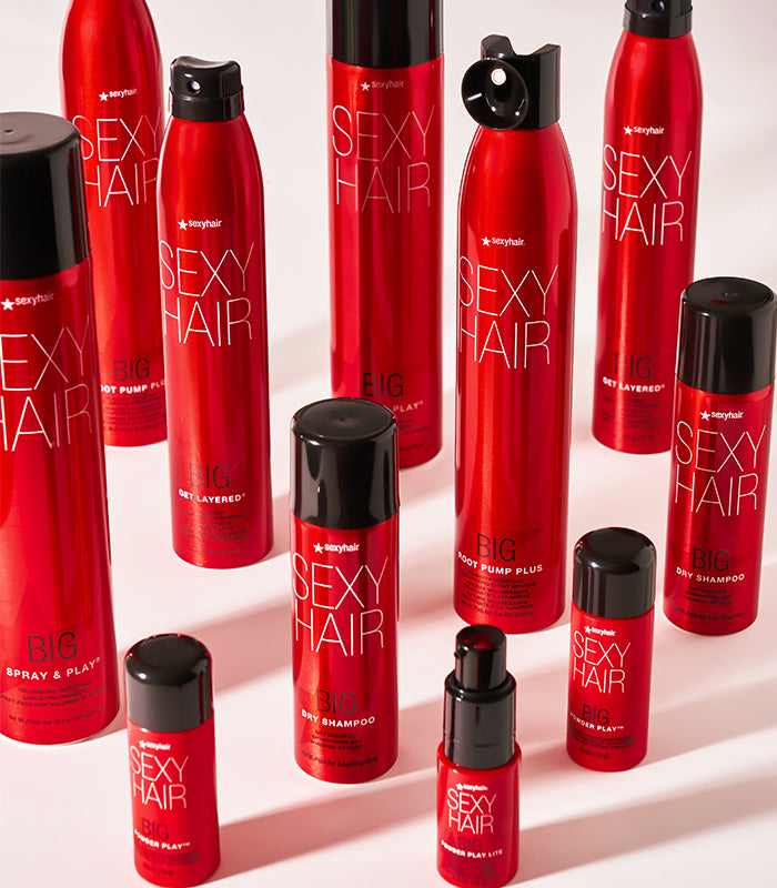 Big styling products arranged with Get Layered spray and hair tools