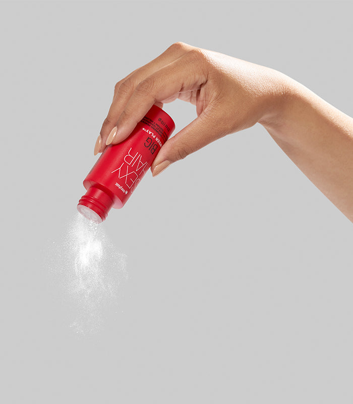 Hand dispensing Big Powder Play texture powder with visible mist
