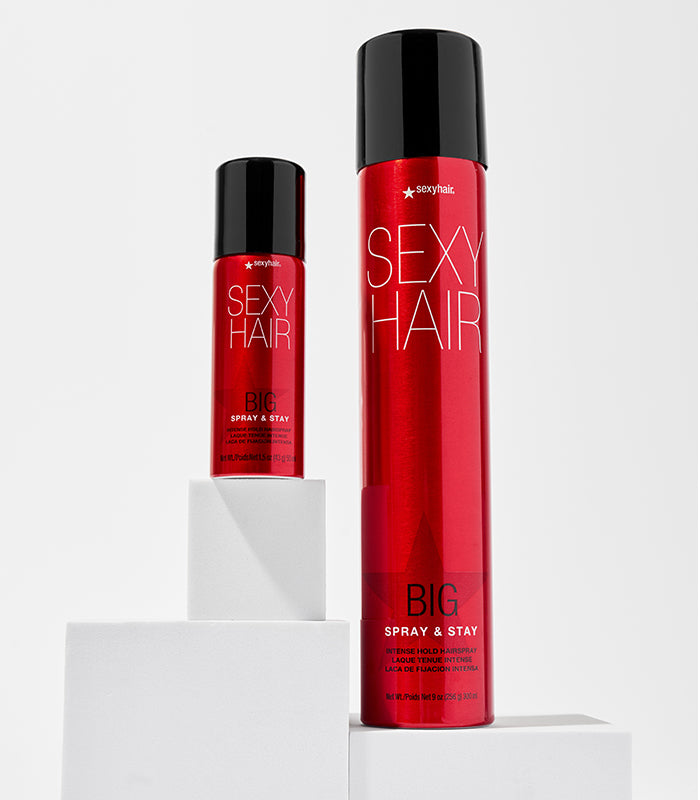 Big Spray & Stay regular and travel sizes on white pedestals