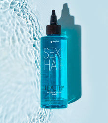 Healthy SexyHair Gloss N' Glow Rinse bottle on blue water texture background
