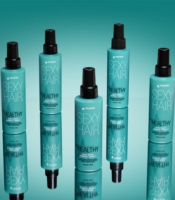 Multiple Healthy SexyHair Shine Show Blowout Spray bottles arranged on teal