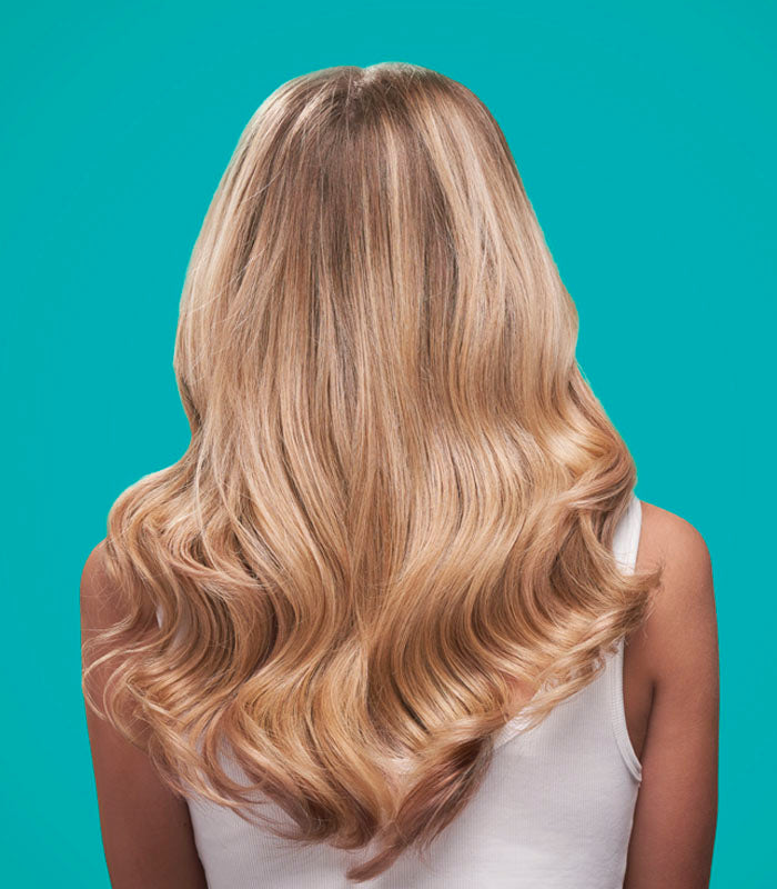 Back view of model with shiny, healthy blonde hair styled with Healthy products