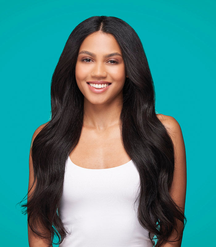 Model with smooth, shiny straight black hair against teal background