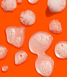 I Want SexyHair Strength shampoo gel texture bubbles on orange background