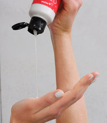 Hand holding I Want SexyHair Volume shampoo bottle dispensing product