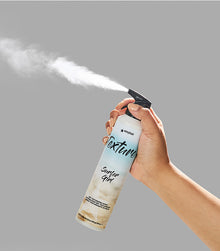 Hand holding Texture SexyHair Surfer Girl spray bottle dispensing product mist